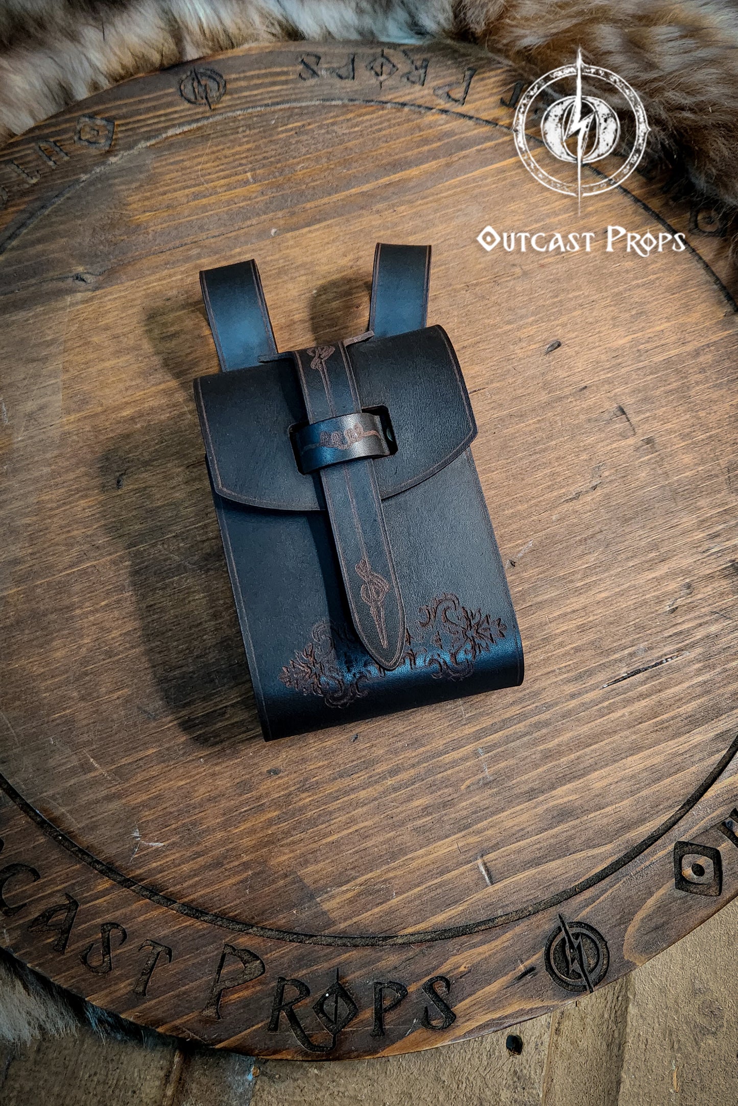 Black leather pouch on a wooden surface with 'Outcast Props' branding. Leather Vial Case for 3 plastic vials. Adventurers, steampunk, alchemist, healers, cosplay or just to keep spices