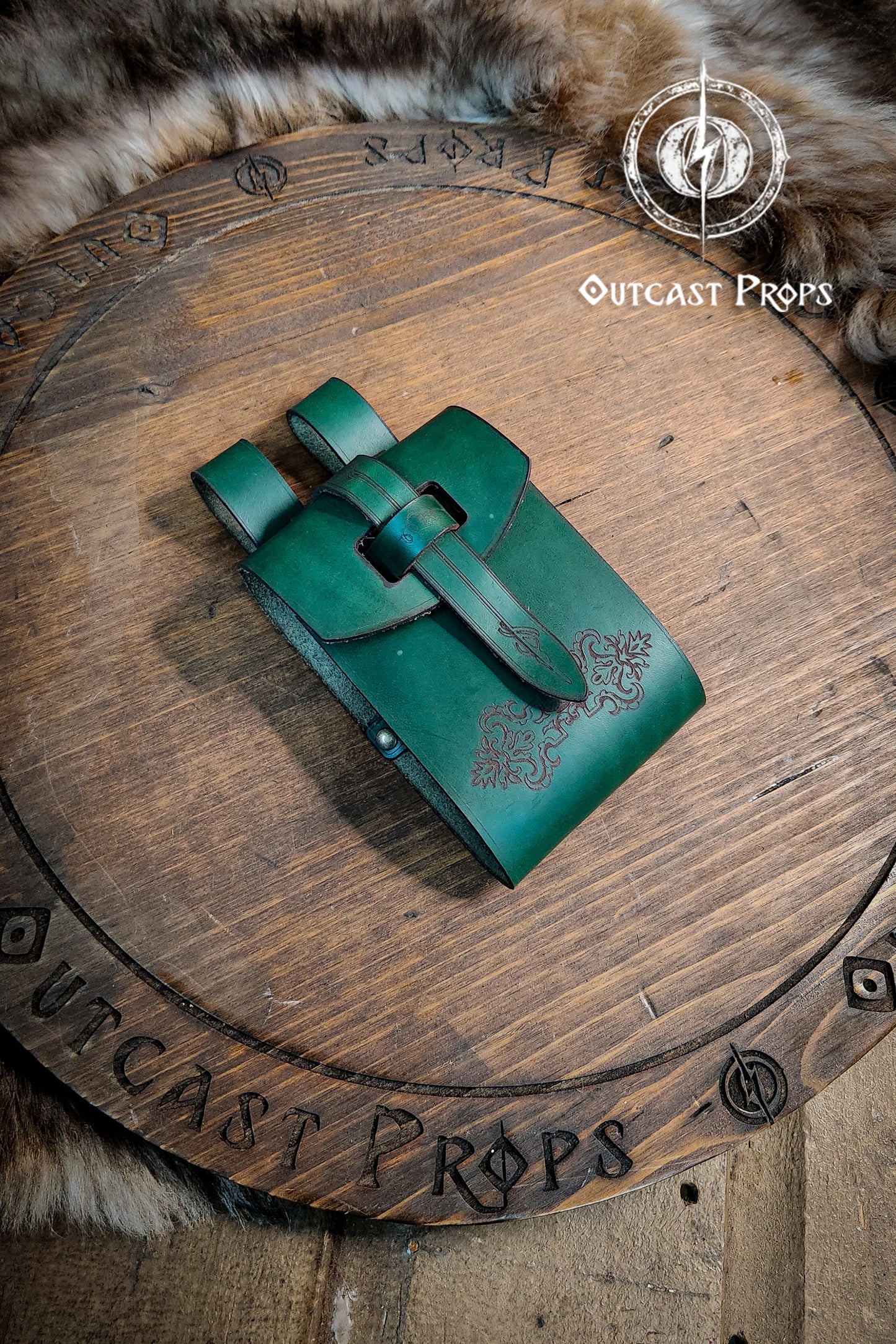 Green leather pouch on a wooden surface with 'Outcast Props' branding. Leather Vial Case for 3 plastic vials. Adventurers, steampunk, alchemist, healers, cosplay or just to keep spices