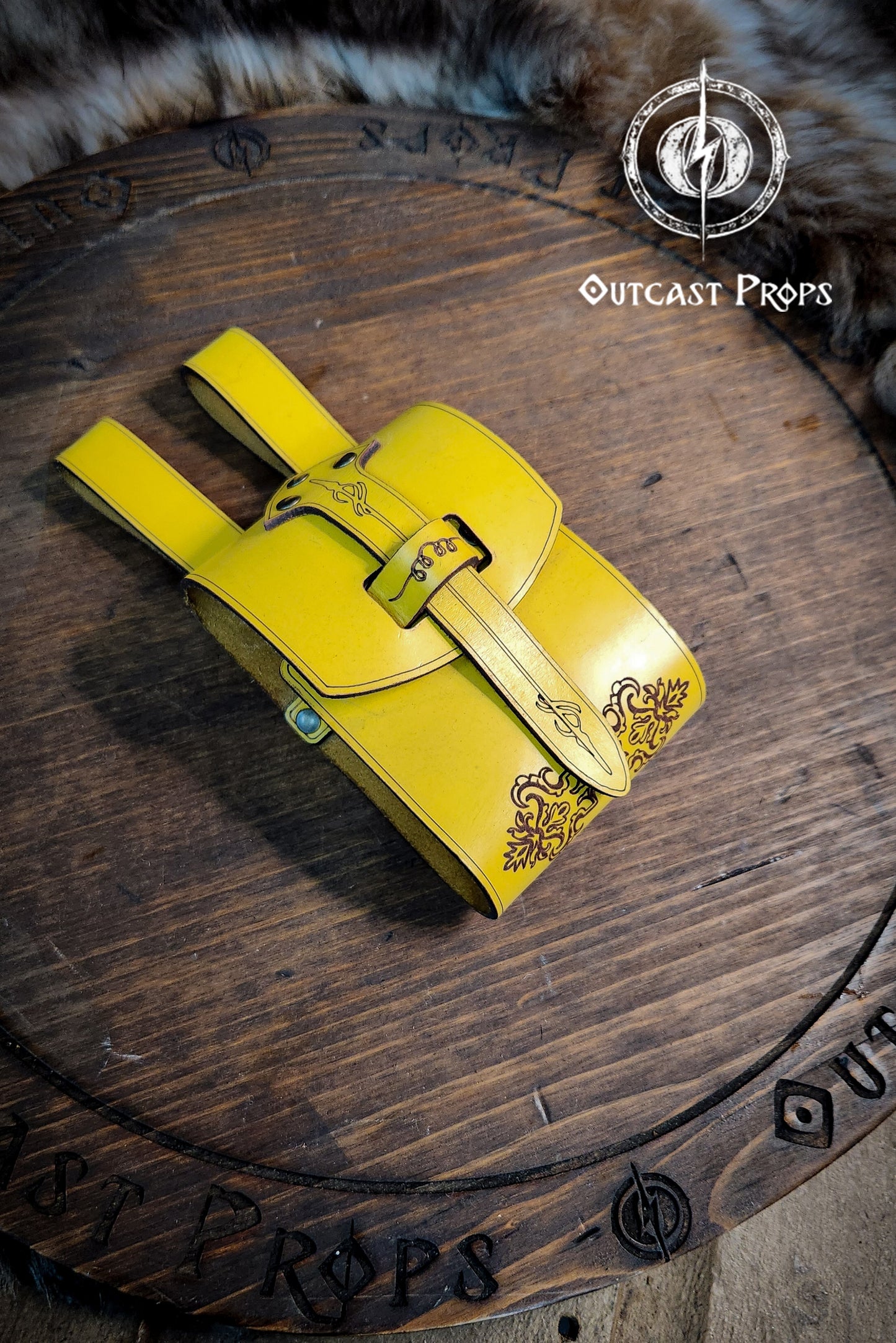 Yellow leather bag with decorative elements on a wooden surface, branded 'Outcast Props'. Leather Vial Case for 3 plastic vials. Adventurers, steampunk, alchemist, healers, cosplay or just to keep spices