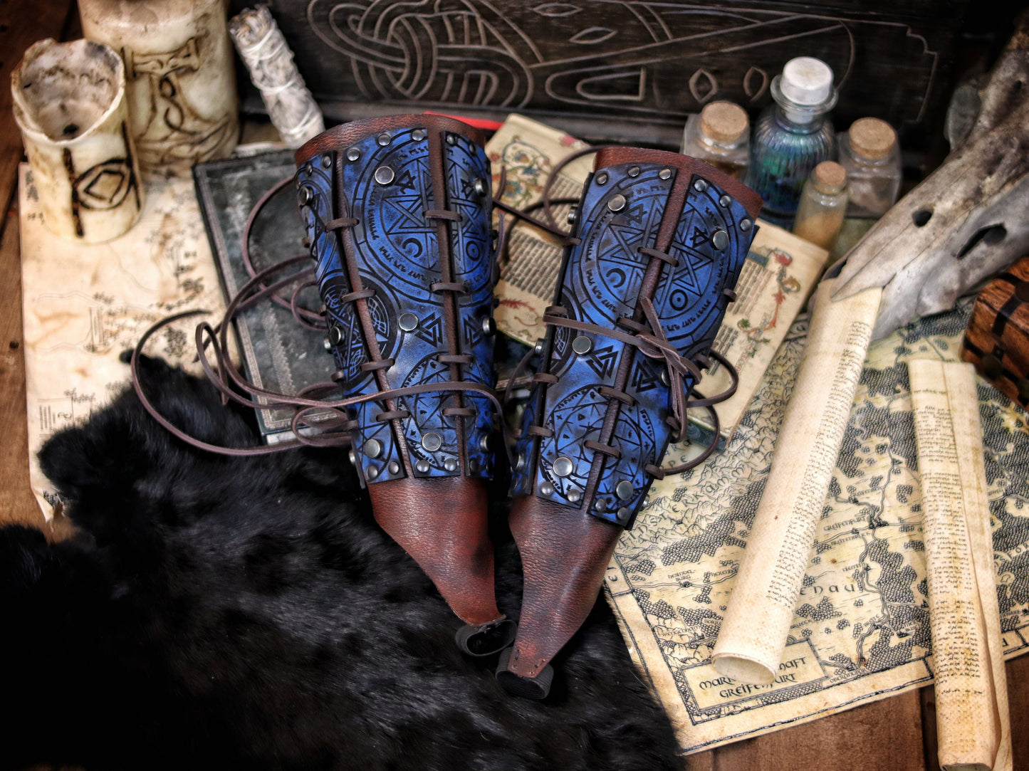 Blue leather bracer for LARP and fantasy cosplay, engraved with alchemical symbols and mystical geometry. Decorated with metal studs and polished beads for a gothic warlock or dark wizard look. Handmade from vegetable-tanned Spanish leather, adjustable and resistant. Perfect for witches, ritualists, or demon hunters in immersive fantasy roleplay.