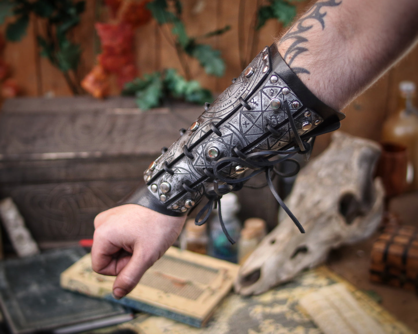 Silver leather bracer for LARP and fantasy cosplay, engraved with alchemical symbols and mystical geometry. Decorated with metal studs and polished beads for a gothic warlock or dark wizard look. Handmade from vegetable-tanned Spanish leather, adjustable and resistant. Perfect for witches, ritualists, or demon hunters in immersive fantasy roleplay.