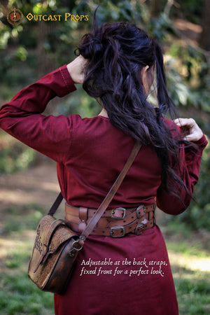Rear view of the Adventurer Leather Belt for medieval LARP and cosplay, worn by a female model with long dark hair. The pirate-style belt wraps around her waist, holding a beautifully engraved leather pouch. This wide leather belt is fully adjustable and perfect for fantasy reenactments, offering space to attach potions, bags, and other role-playing essentials with quick access during battle scenes.