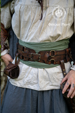 Person wearing historical clothing with a belt and pouches, featuring 'Outcast Props' logo.