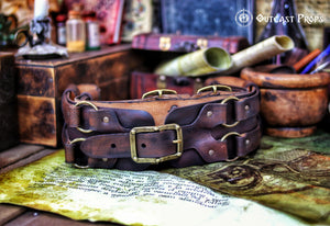 Rustic adventurer leather belt displayed atop a fantasy map with scrolls and potion bottles. This steampunk wide leather belt is handmade from full-grain leather, aged for a battle-worn finish. Perfect for cosplay, pirate reenactments, and Renaissance fairs, it offers adjustable comfort and accessory loops. A versatile and durable LARP belt for medieval and fantasy role-playing characters.