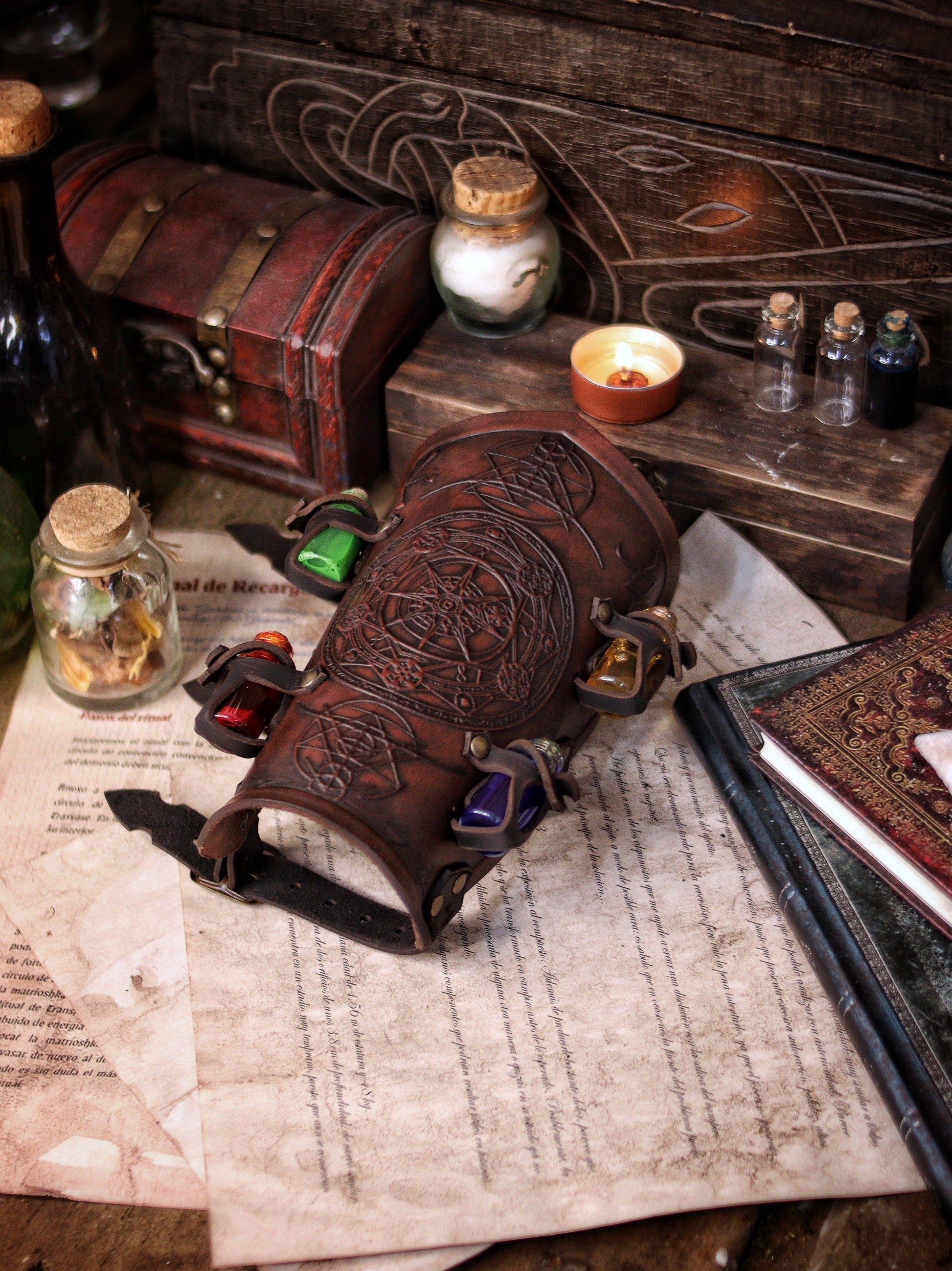 A leather bracer with metal rivets and straps, featuring intricate alchemical circles and small glass vials for storing liquids. Alchemist leather bracer with transmutation circle larp armor Wizards sorcerers and masters of the occult and the arcane