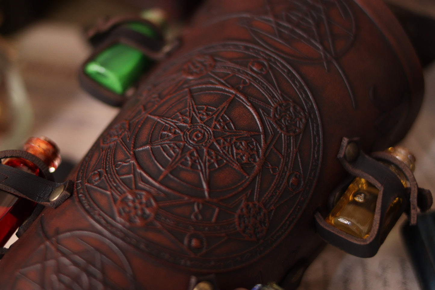 A leather bracer with metal rivets and straps, featuring intricate alchemical circles and small glass vials for storing liquids. Alchemist leather bracer with transmutation circle larp armor Wizards sorcerers and masters of the occult and the arcane