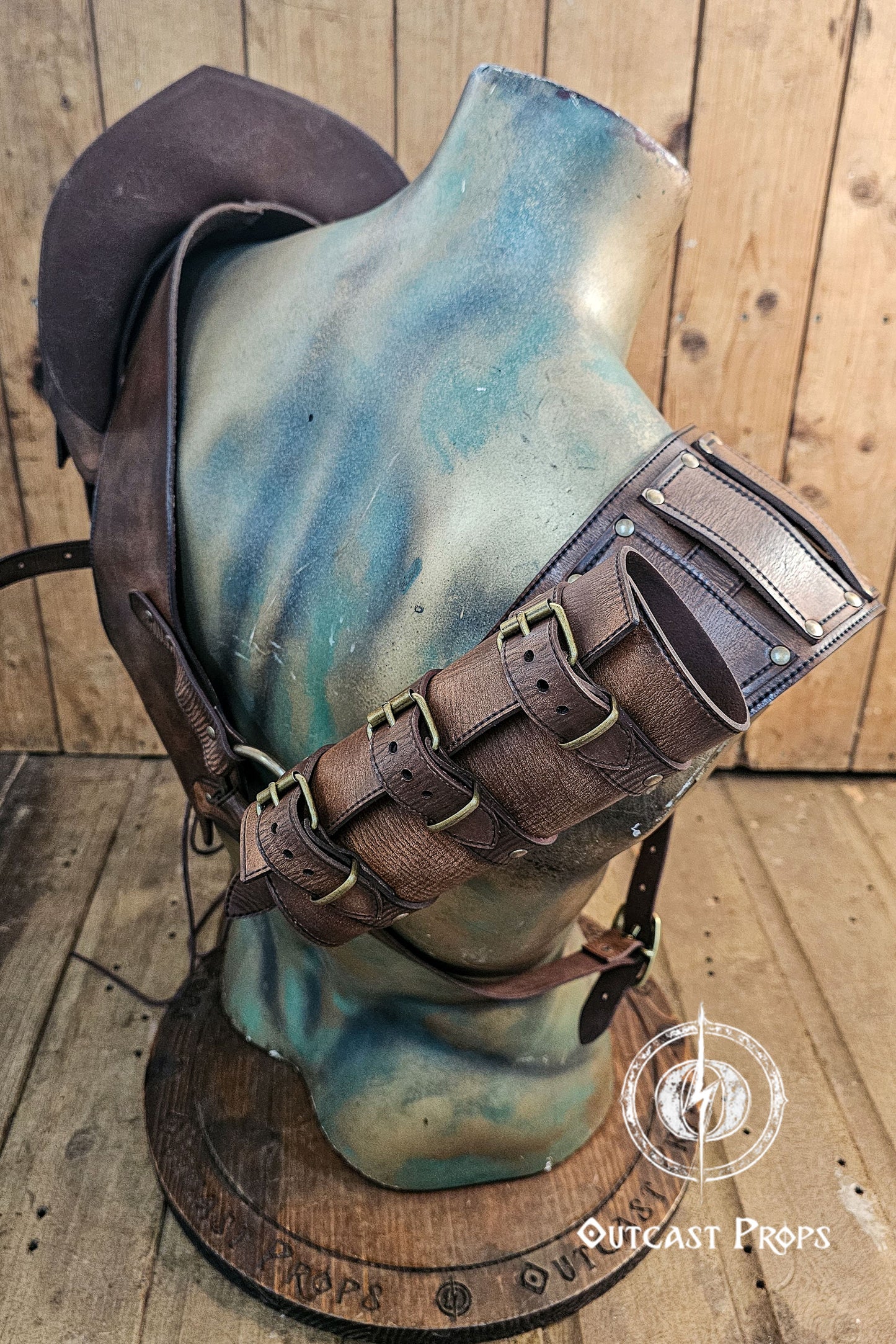 Back view of the full leather shoulder harness and double pauldron set. Sword scabbard runs diagonally from shoulder to waist. The brown leather is distressed with handcrafted aging and riveted panels. Adjustable straps and buckles allow versatile fitting. Perfect leather shoulder armor for larp viking outfit, barbarian cosplay, and post-apocalyptic costume accessories.