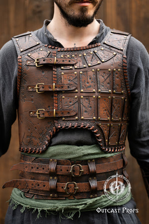 Close-up of a handcrafted leather chestplate for barbarian warriors, showing the detailed embossed panels and studs. The armor includes three frontal buckles and weathered textures that give a battle-worn, gritty appearance. Ideal for LARP armor sets, fantasy characters or viking costumes. Features premium vegetable-tanned leather with cinematic painting, crafted by Outcast Props. Viking Studded Leather Armor Chest Armor for Men LARP Armor Witcher Leather Armour Medieval Leather Armor Cosplay Armor Fantasy