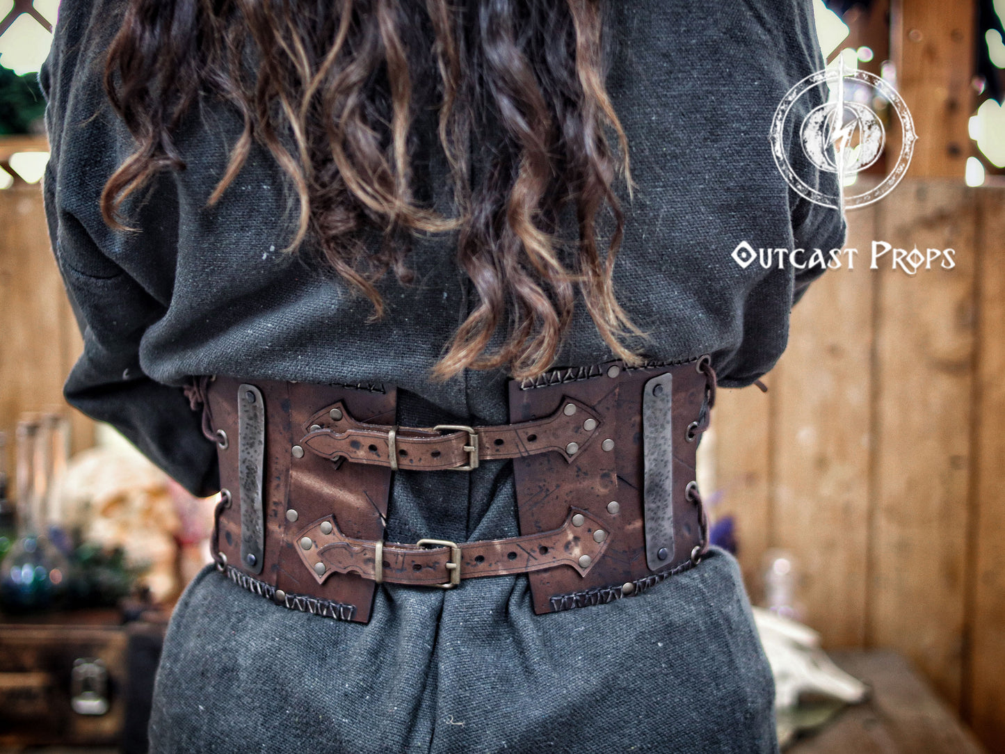Person wearing a detailed leather belt with Outcast Props branding. Barbarian Leather armor woman, larp armor woman viking piece woman post apocalyptic cosplay