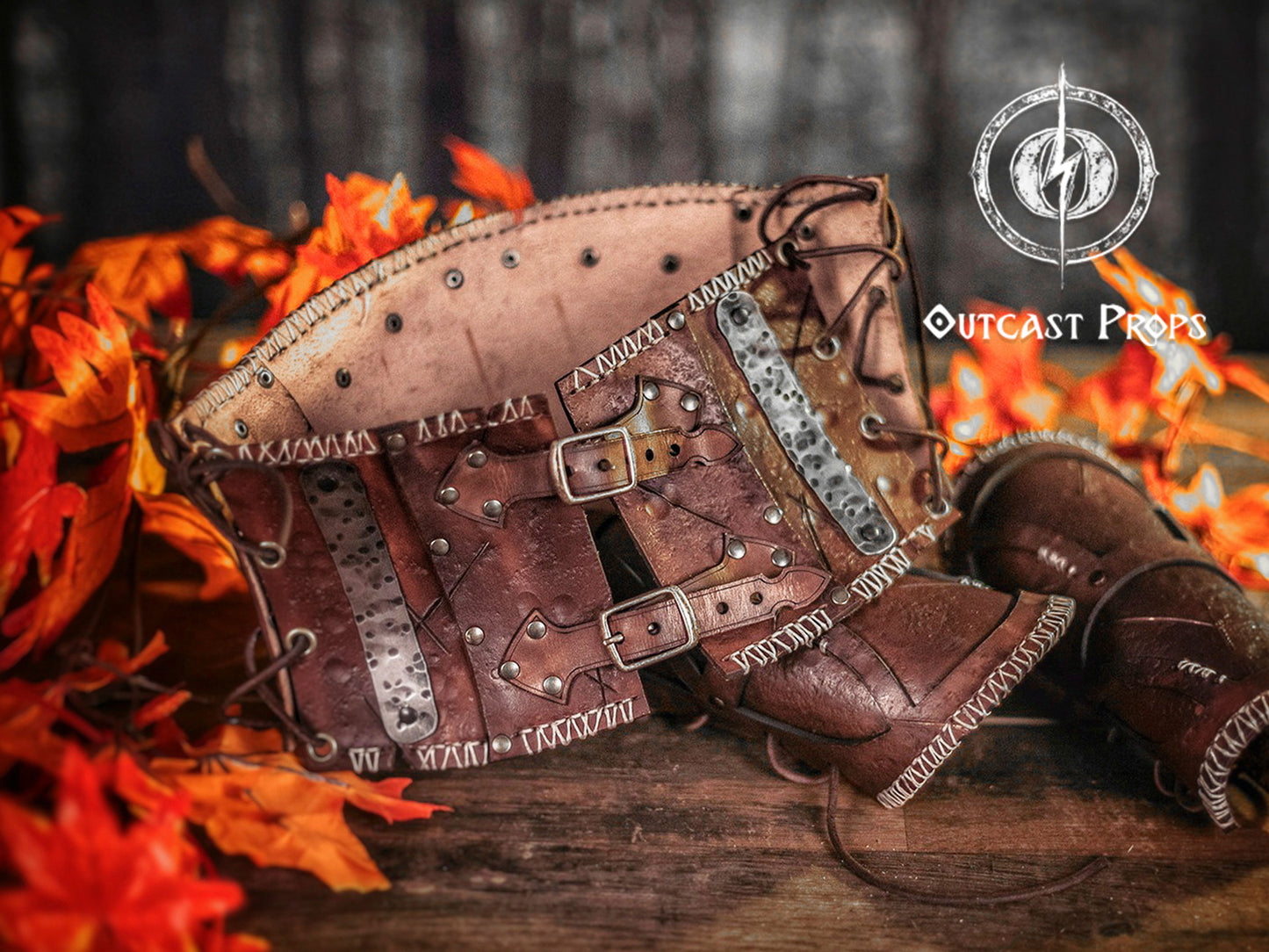 Brown leather belt with metal accents on a wooden surface with autumn leaves and blurred background. Barbarian Leather armor woman, larp armor woman viking piece woman post apocalyptic cosplay