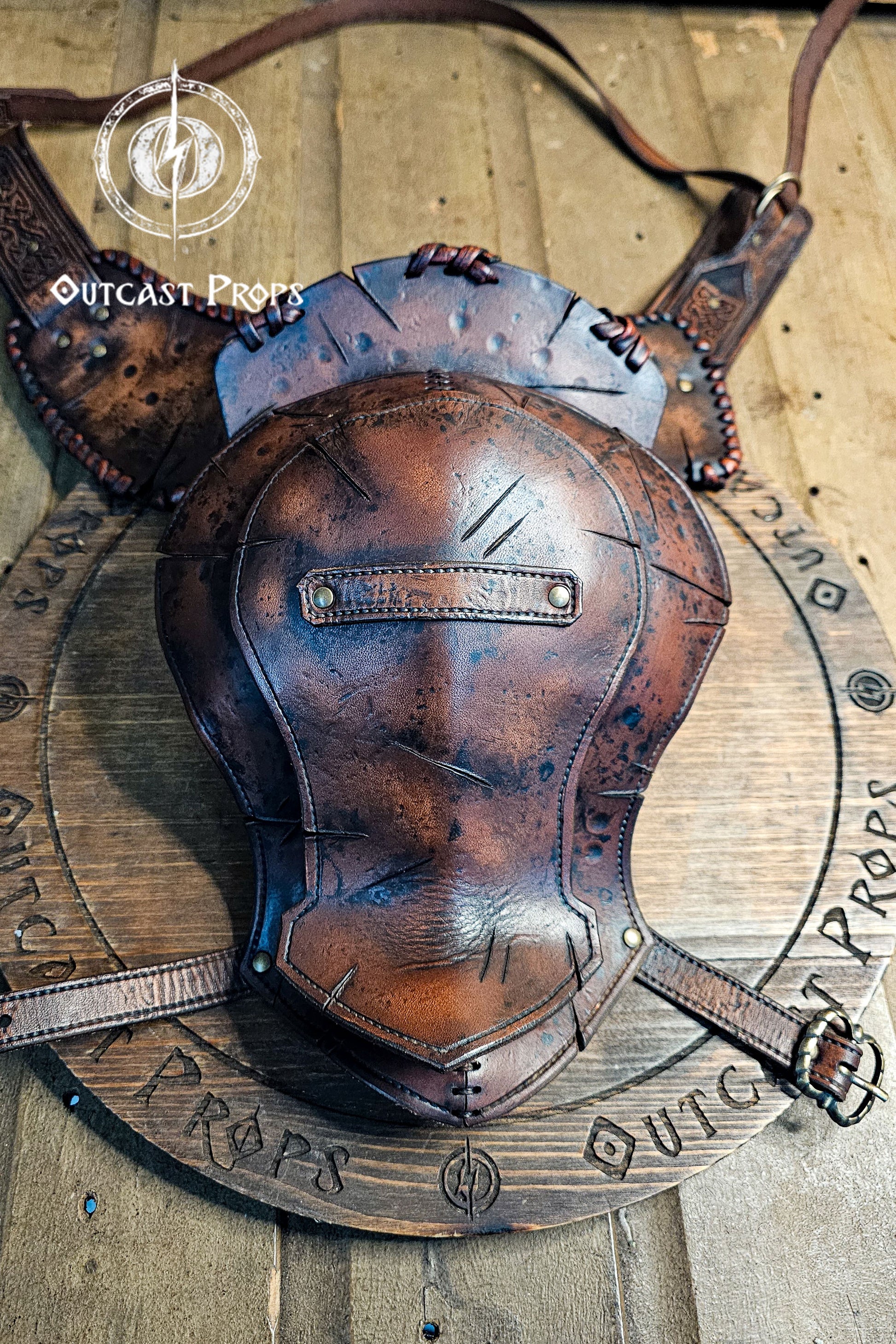 Barbarian Viking Leather Shoulder armor set. Brown leather armor piece on a wooden background with 'Outcast Props' branding.