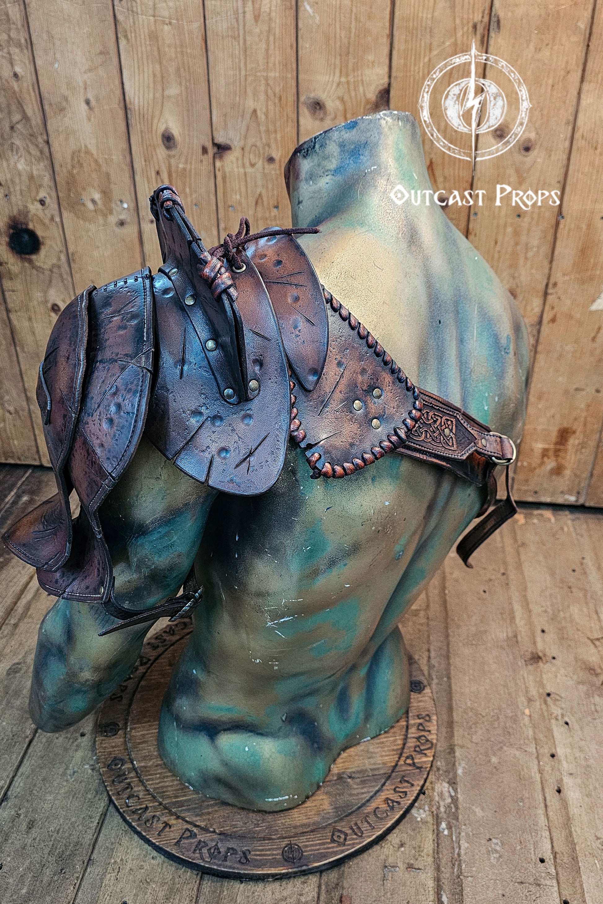 Barbarian Viking Leather Shoulder armor set. Decorative armor with leather straps on a mannequin bust against a wooden background, branded 'Outcast Props'.
