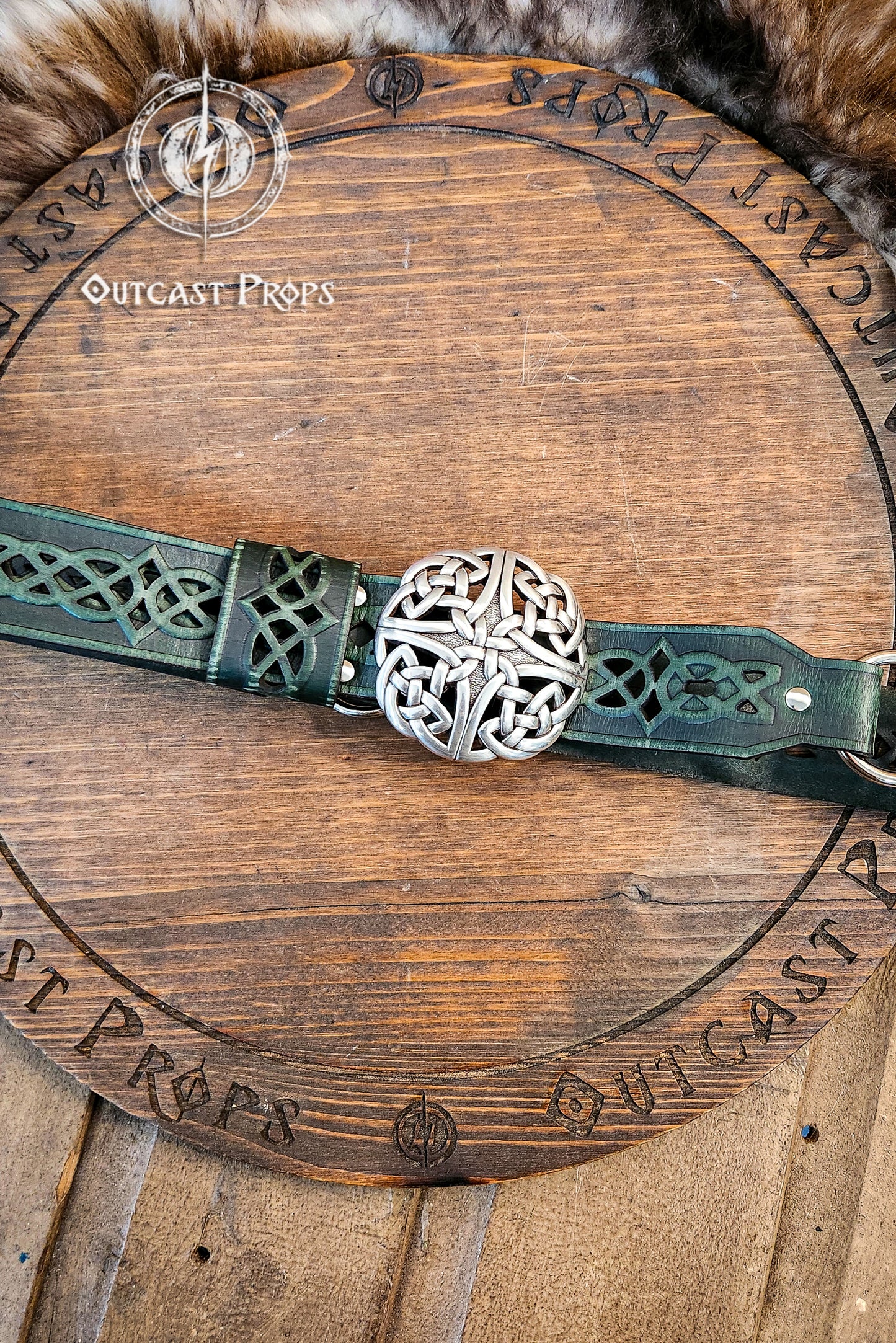 Green leather belt with silver buckle on a wooden surface, branded 'Outcast Props'. Celtic knot leather belt silver buckle larp belt for ren fair fantasy costume celtic belt unisex leather belt for renaissance outfit