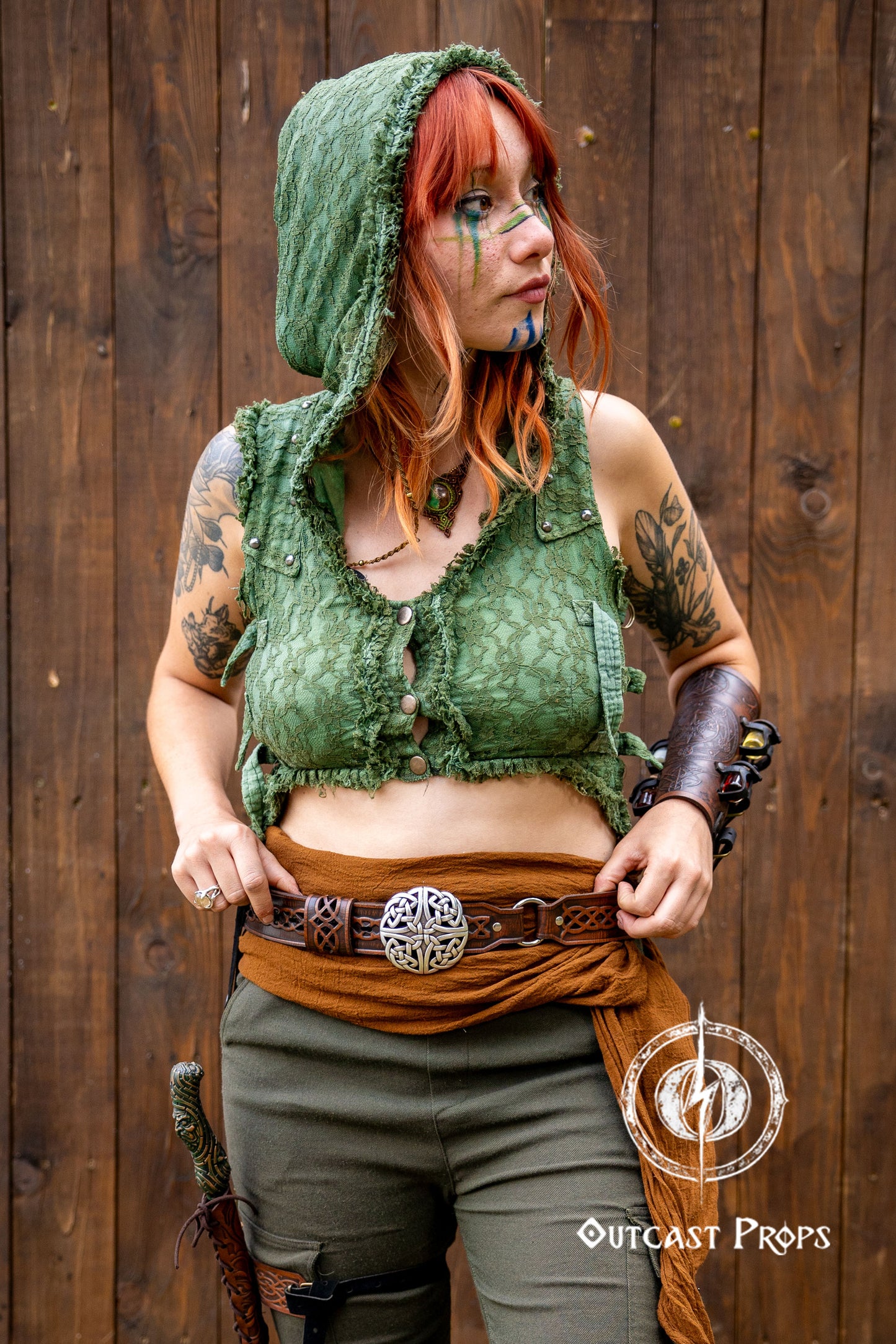 Person in green hooded outfit with tattoos against a wooden background, Celtic knot leather belt silver buckle larp belt for ren fair fantasy costume celtic belt unisex leather belt for renaissance outfit
