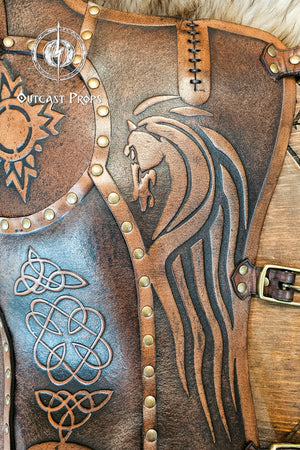 Close-up of aged brown Celtic leather greave handcrafted from full-grain vegetable-tanned leather, showing a detailed embossed horse motif inspired by the Rohirrim riders of Middle-earth. Surrounded by Celtic knotwork and brass rivets, it captures the essence of Viking and medieval craftsmanship. Ideal for LARP armor, fantasy horsemen, or reenactment costumes that demand authentic handmade detailing.