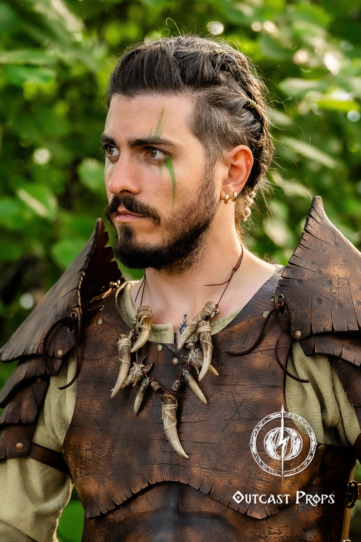 Person wearing a detailed leather outfit with decorative elements, standing outdoors. Celtic Tusk Necklace Viking ornament Tribal Shaman Druid with realistic resin fangs Orc LARP cosplay and post-apocalypse marauder