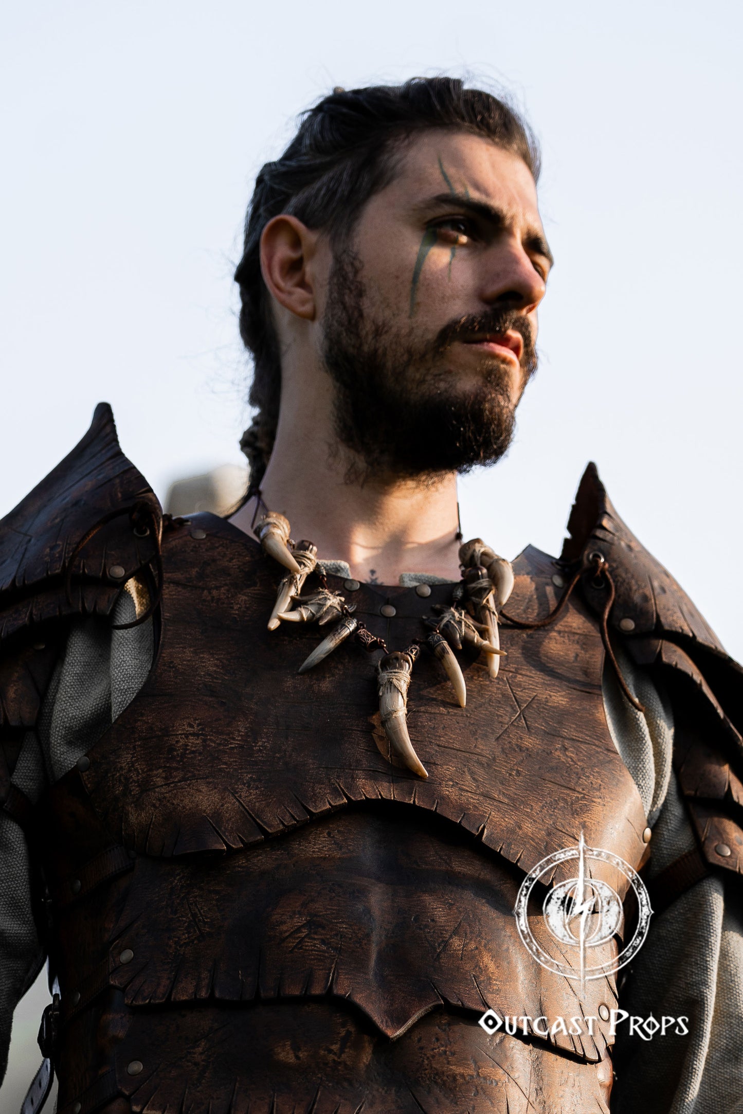 Person wearing detailed armor with a neutral background. Celtic Tusk Necklace Viking ornament Tribal Shaman Druid with realistic resin fangs Orc LARP cosplay and post-apocalypse marauder