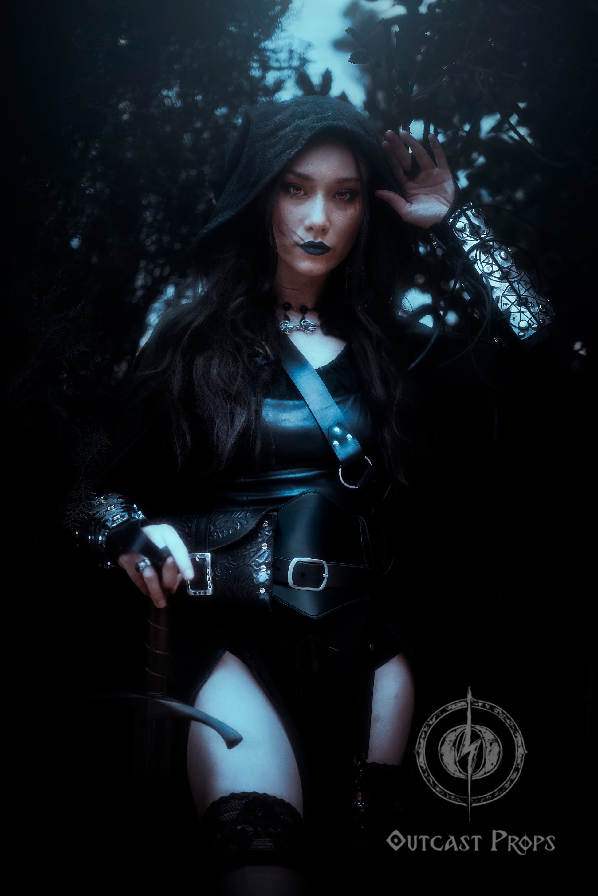 Sorceress in black cloak wearing pair of silver engraved bracers with magical protection symbols. Perfect for cosplay witches, warlocks, or demon hunter characters. These leather vambraces are handcrafted with riveted construction, elastic finger loops, and aged finish for a legendary look. Designed for gothic LARP, fantasy conventions or dark rituals.