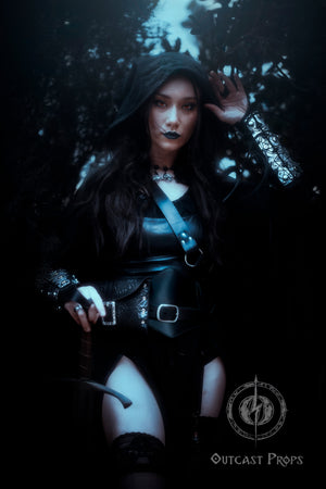 Sorceress in black cloak wearing pair of silver engraved bracers with magical protection symbols. Perfect for cosplay witches, warlocks, or demon hunter characters. These leather vambraces are handcrafted with riveted construction, elastic finger loops, and aged finish for a legendary look. Designed for gothic LARP, fantasy conventions or dark rituals.