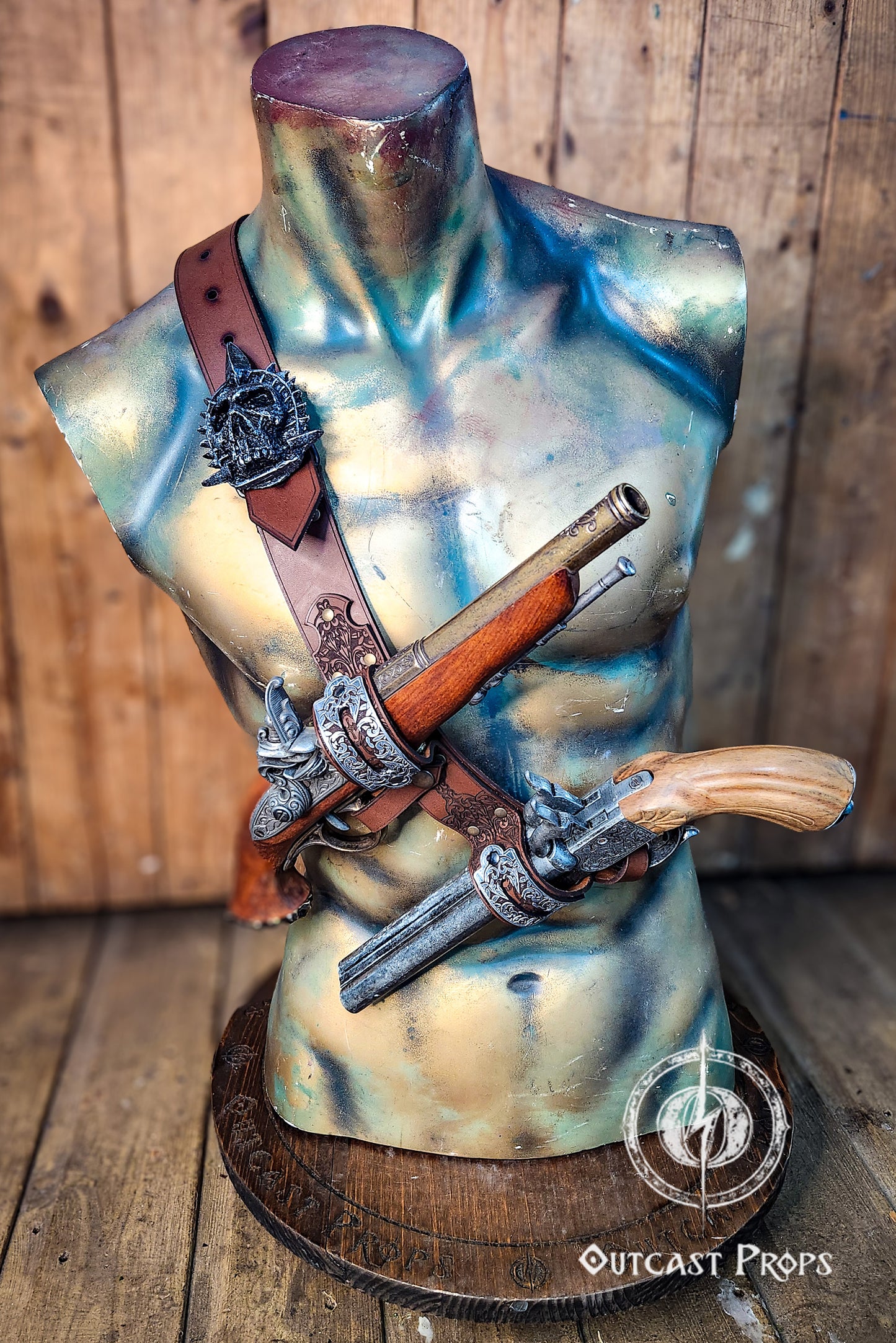 Light brown leather baldric across a sculpted bust, showcasing two replica flintlock pistols in ornate silver holders. The pirate shoulder strap is a tribute to Edward Kenway from Assassins Creed, blending historical flair and cosplay detail. Ideal for pirate LARP gear, Assassins Creed costume sets, or Edward Kenway cosplay fans seeking authenticity and durability.