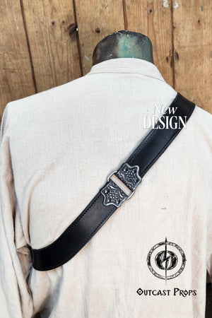 Edward Kenway pirate cosplay. Close-up of the back of a mannequin wearing the Edward Kenway baldric in black leather. The embossed strap runs diagonally over the shoulder, featuring a silver-toned buckle with floral pirate-era motifs. Ideal for cosplay, LARP or ren faire costumes inspired by Black Sails or Assassinβs Creed. The baldric's craftsmanship and texture evoke historical elegance and rugged functionality.