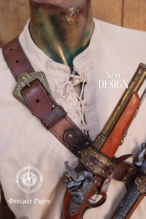 Edward Kenway pirate cosplay. Detail of the upper section of a leather baldric showing embossed patterns and dual buckles in aged brass, holding two vintage flintlock props. The design is reminiscent of pirate or privateer aesthetics, with high-quality vegetable-tanned leather. Suitable for Edward Kenway cosplay, LARP pirates, or steampunk characters. Elegant and practical for costume use, offering secure weapon retention with historical flair.