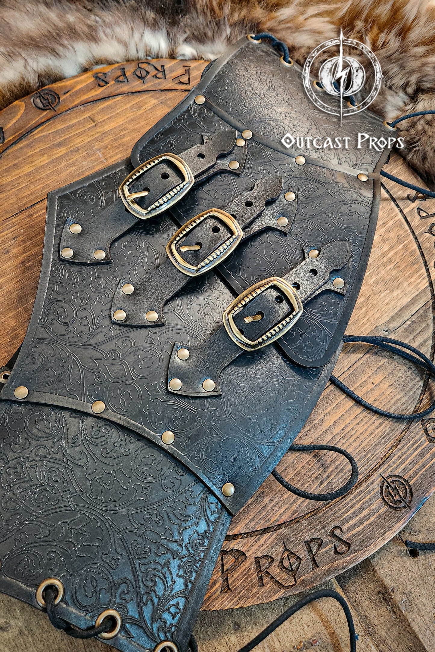 Leather underbust with embossed design and gold buckles on a wooden background. Leather Corset. Elegant underbust por cosplay and larp. Pirate corset. Pirate underbust.