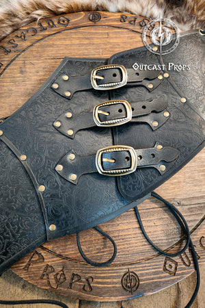 Leather underbust with embossed design and gold buckles on a wooden background. Leather Corset. Elegant underbust por cosplay and larp. Pirate corset. Pirate underbust.
