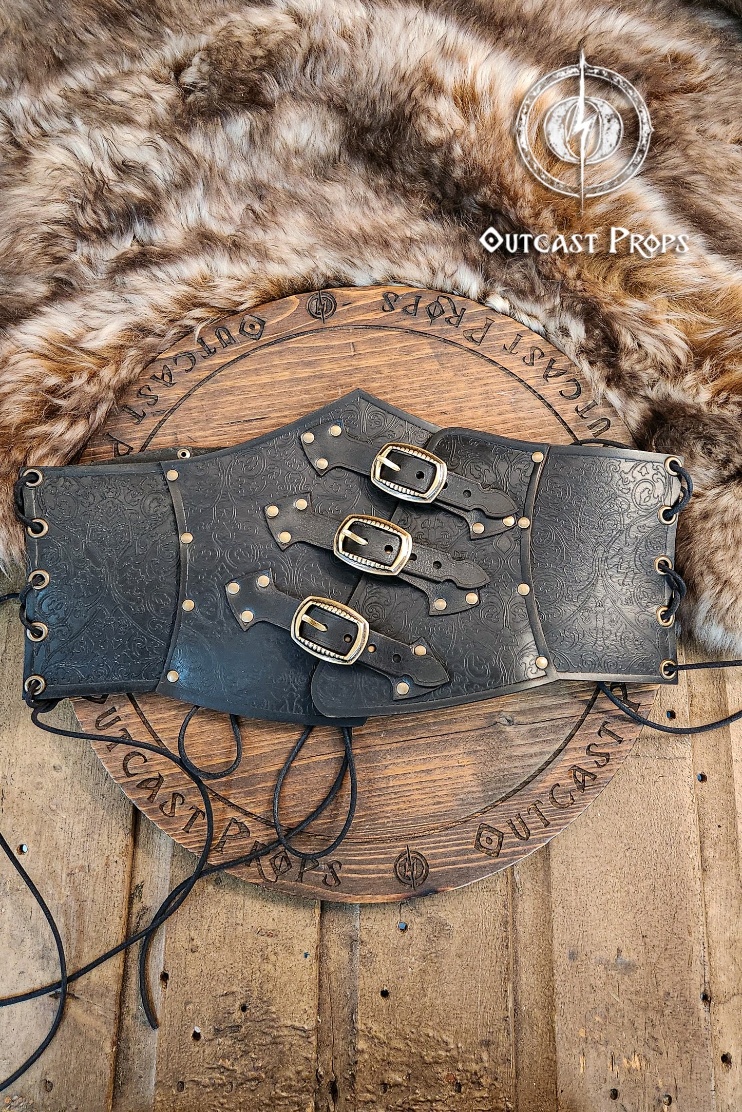 Leather underbust with embossed design and gold buckles on a wooden background. Leather Corset. Elegant underbust por cosplay and larp. Pirate corset. Pirate underbust.