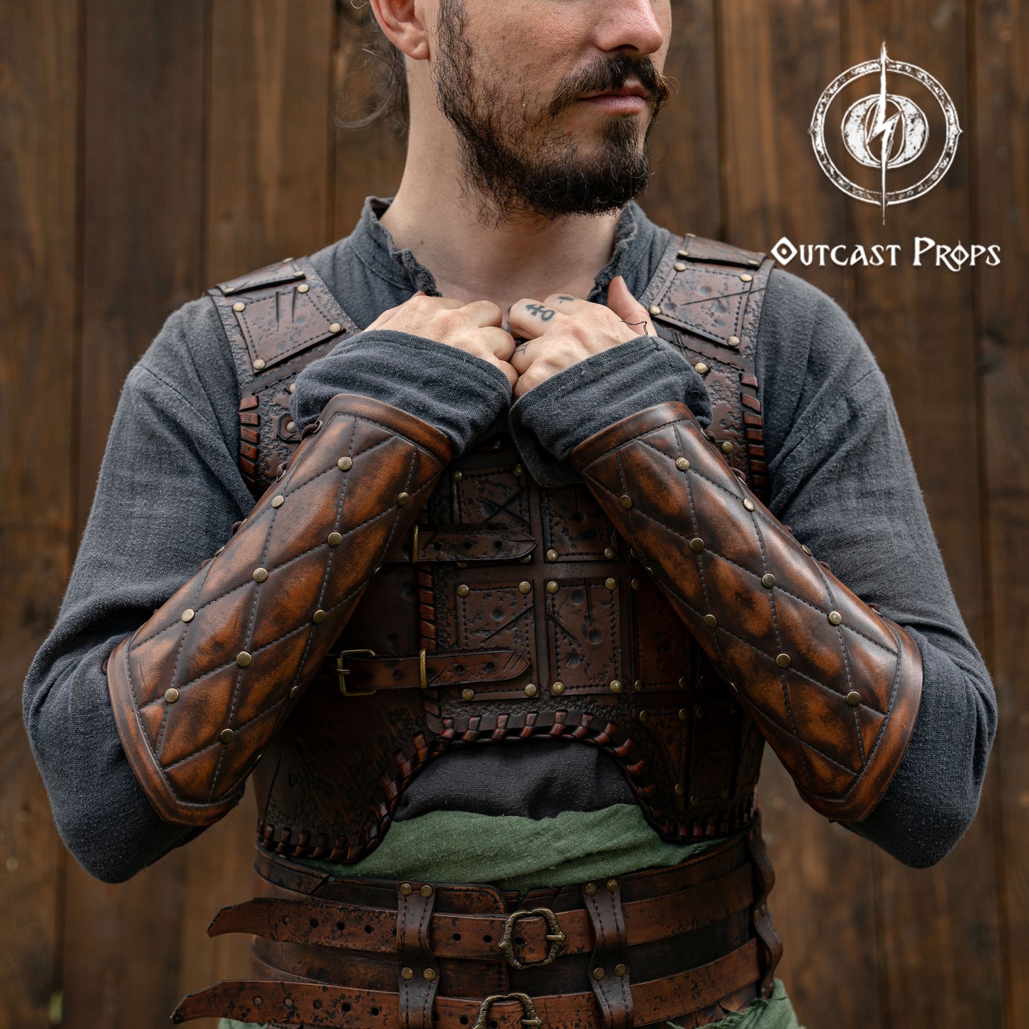 Falken leather bracers for noble costume LARP outfit medieval fantasy accessories for Ren Faire cosplay arm guards for knight character gear. Person wearing a detailed leather armor with 'Outcast Props' logo in the corner.