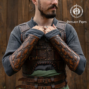 Falken leather bracers for noble costume LARP outfit medieval fantasy accessories for Ren Faire cosplay arm guards for knight character gear. Person wearing a detailed leather armor with 'Outcast Props' logo in the corner.