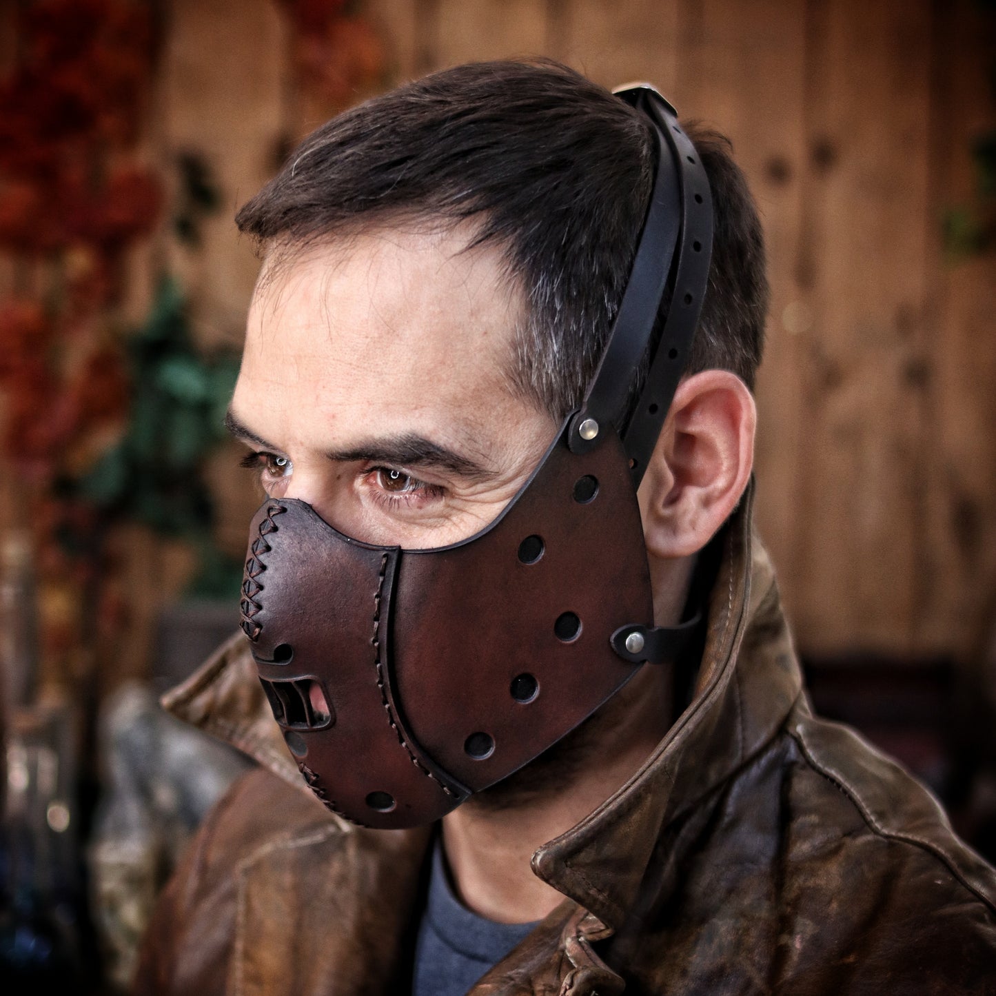 A person wearing a leather mask designed to resemble Hannibal Lecter's . Hannibal Lecter Leather Face Mask horror mask Halloween mask,human muzzle, cannibal mask, cosplay costume or larp mask.