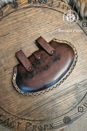 Back view of noble pear shape leather pouch in aged brown, crafted with vegetable tanned leather and two belt loops. The renaissance small pouch shows hand-stitched borders and subtle weathered texture, emphasizing artisan quality. Designed for LARP and renaissance costume accessories, it evokes historical charm and eco-friendly craftsmanship by Outcast Props.