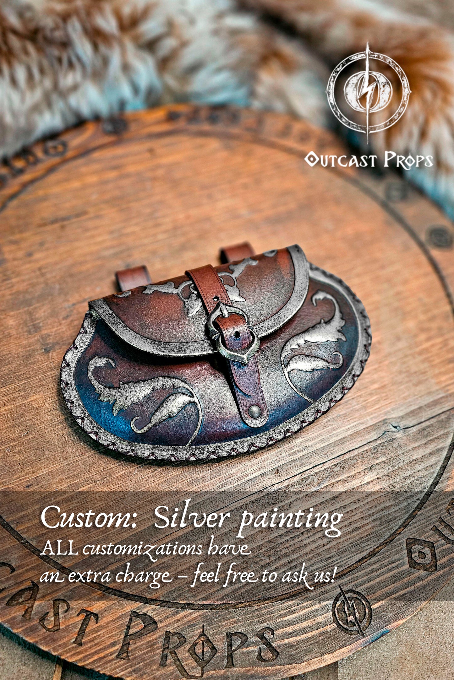 Small pear shape leather pouch in aged black with silver edges and motifs, lying on engraved wooden board with fur background. The renaissance belt bag shows refined silver-painted details, stitched trim, and nickel buckle. Ideal for LARP pouch lovers, medieval fairs, and noble costume accessories handmade from vegetable-tanned leather by Outcast Props.