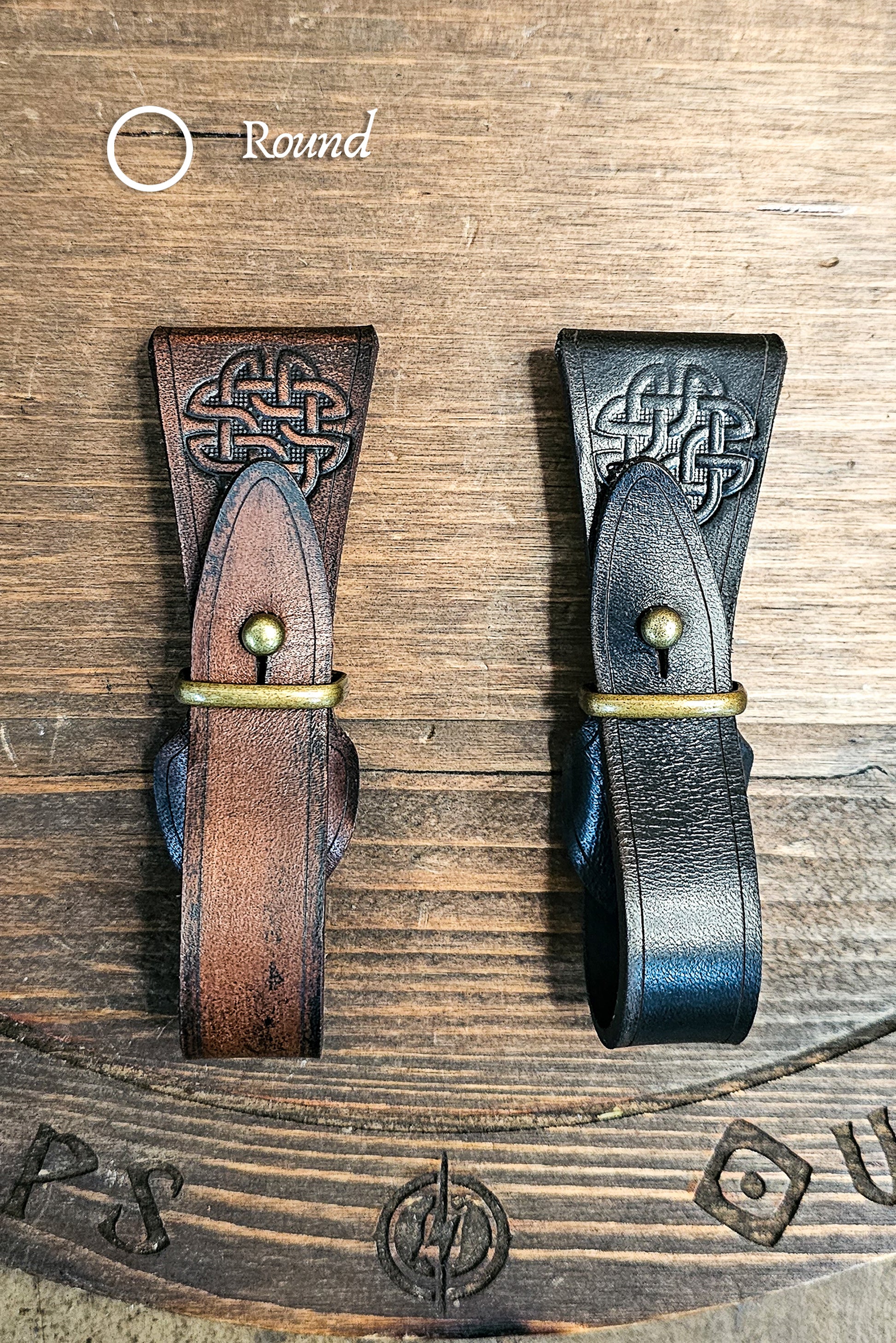 Two leather straps with Celtic knot designs on a wooden surface. Medieval Leather Tankard Strap: Renaissance Faire Belt up to 6 cm or 2,4 inches. Accessory for Viking Cosplay, LARP, and Celtic Costumes