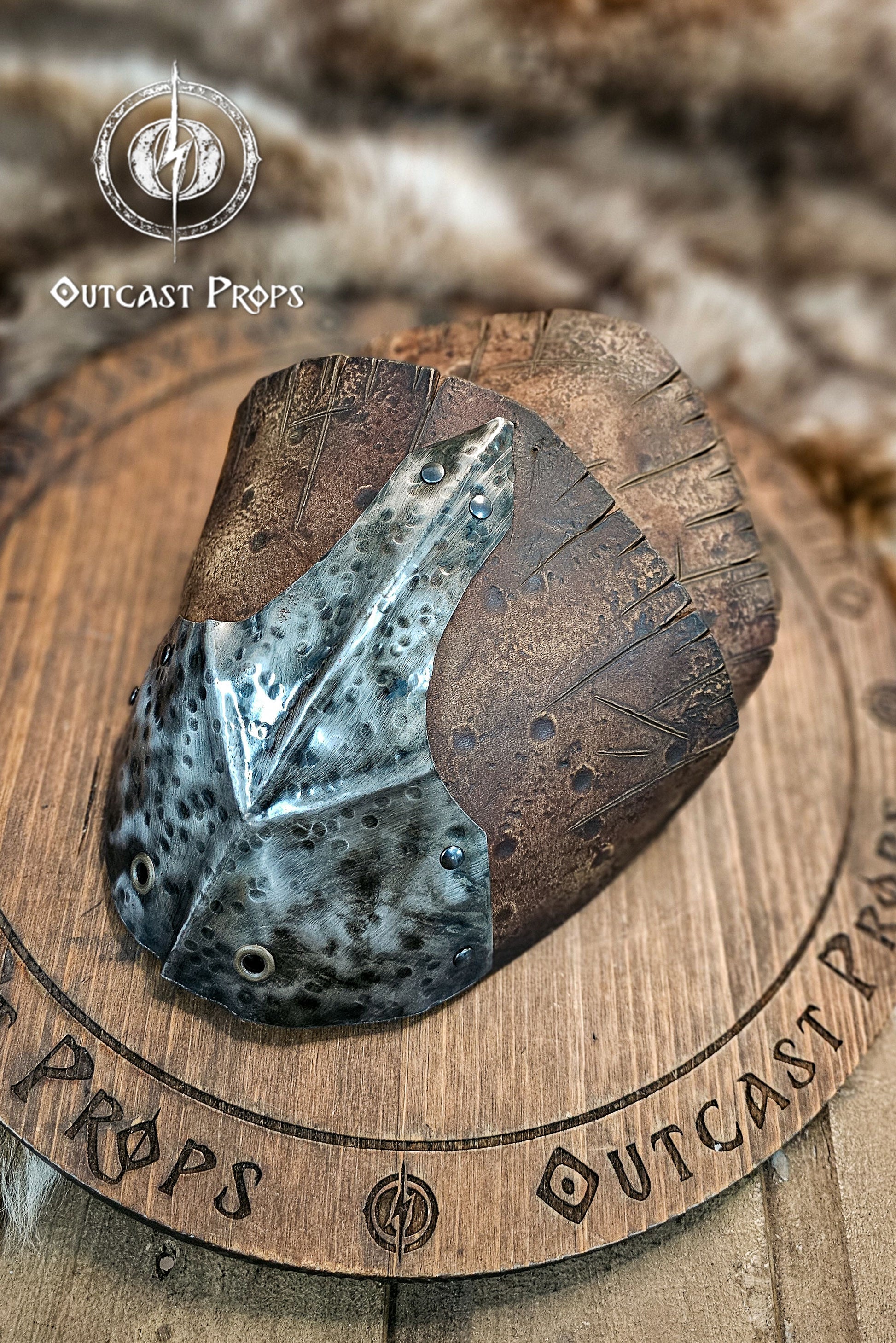 Angled shot of the Outcast Props leather and metal pauldron showing the hammered iron plate and thick, darkened leather layers. The design blends Viking raider aesthetics with rough orcish style, perfect for barbarian characters in LARP, fantasy battles, or cosplay. Every plate is shaped, riveted, and aged by hand to achieve a cinematic, battle-worn texture.