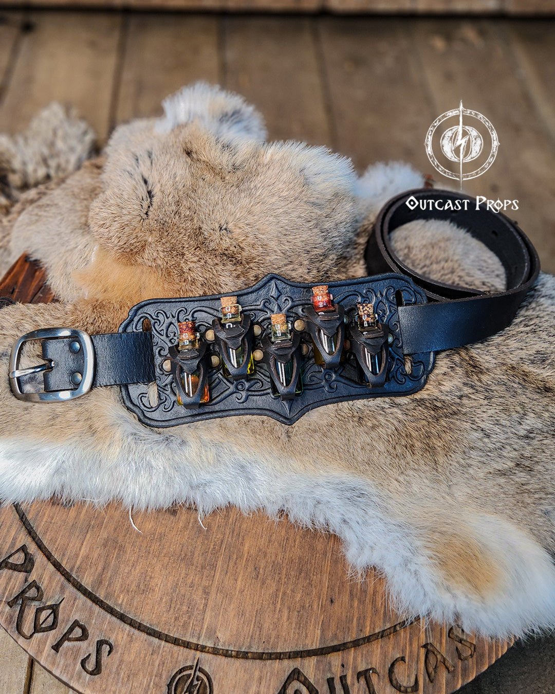 A handmade leather potion holder with ornate embossed patterns, designed to hold five small glass vials. The holder is displayed on a furry surface, and the vials have cork stoppers. Ornated Belt potion holder | 5 potion Belt carrier | LARP, cosplay, fantasy alchemist accessory, adventurers, steampunk, alchemist, healers