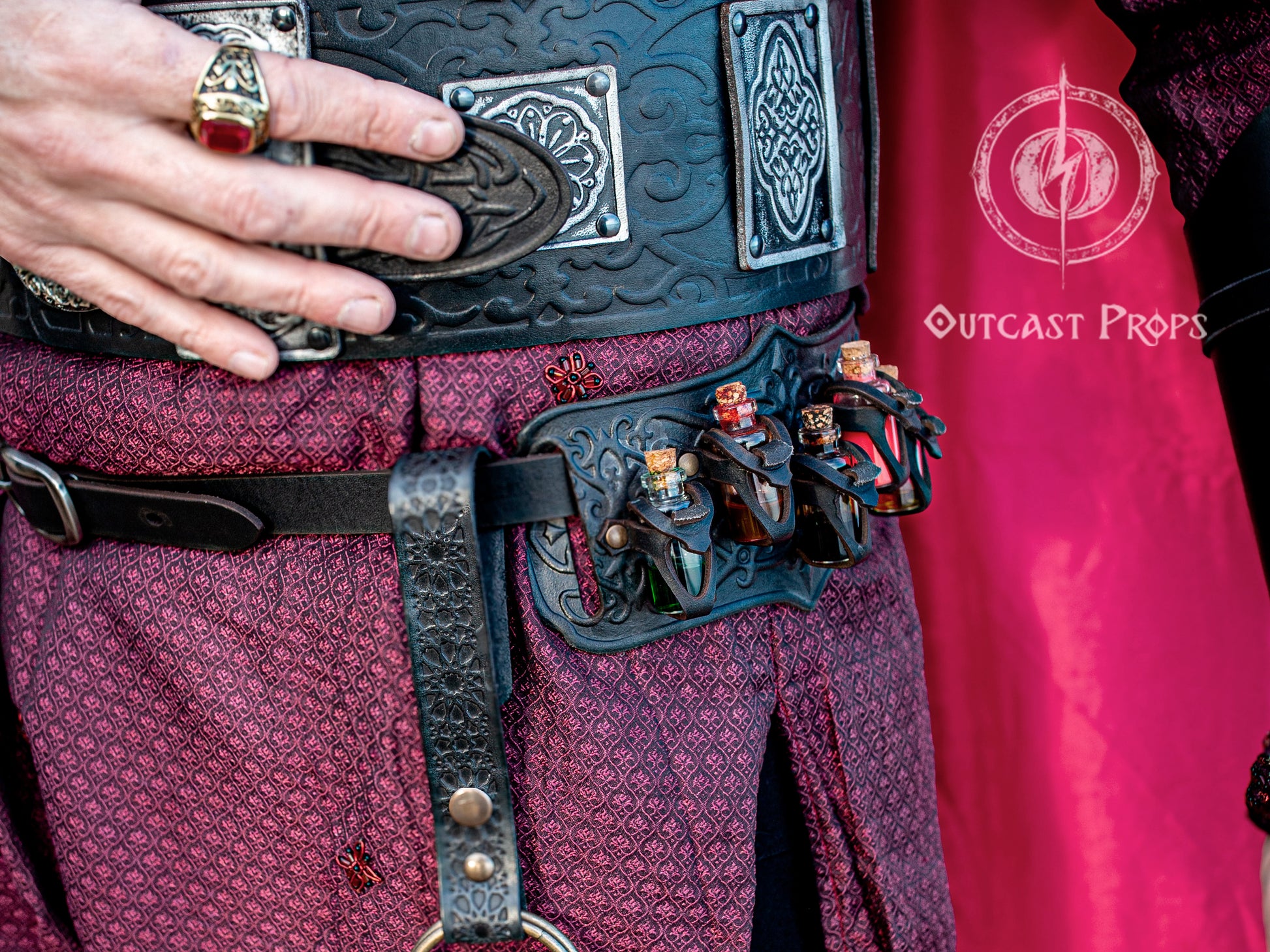 A handmade leather potion holder with ornate embossed patterns, designed to hold five small glass vials. The holder is displayed on a furry surface, and the vials have cork stoppers. Ornated Belt potion holder | 5  potion Belt carrier | LARP, cosplay, fantasy alchemist accessory, adventurers, steampunk, alchemist, healers