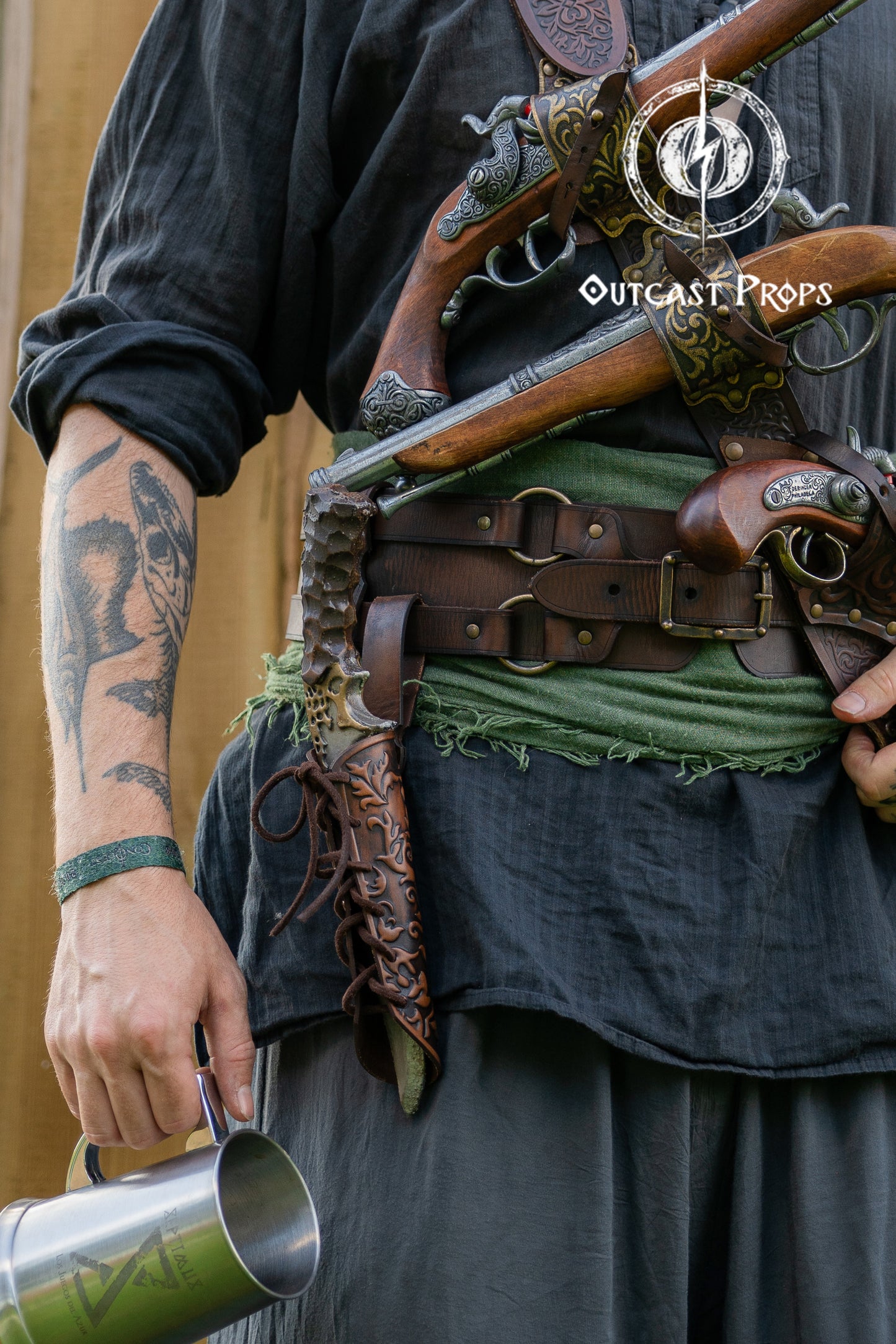 Person in historical or fantasy costume with weapons and a belt, featuring 'Outcast Props' branding. Handmade leather dagger sheath | Ornate LARP scabbard | Viking, medieval, fantasy belt holster for daggers | Ren Faire cosplay accessory