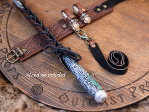 Decorative wand holder with tassel on a wooden surface