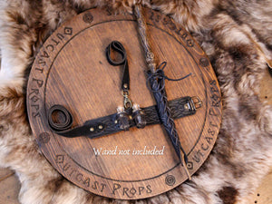 Black leather garter set with potion holders and wand sheath shown on fur and wood surface. Features include two potion bottles, embossed leather design, and adjustable straps. The wand is secured in the lace-up holster (not included). Suitable for black wizard thigh holster, dark witch potion garter, LARP leg strap for fantasy wand cosplay.
