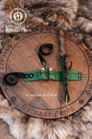 Wooden circle with green and black decorative item, surrounded by fur, on a wooden surface with 'Outcast Props' branding.