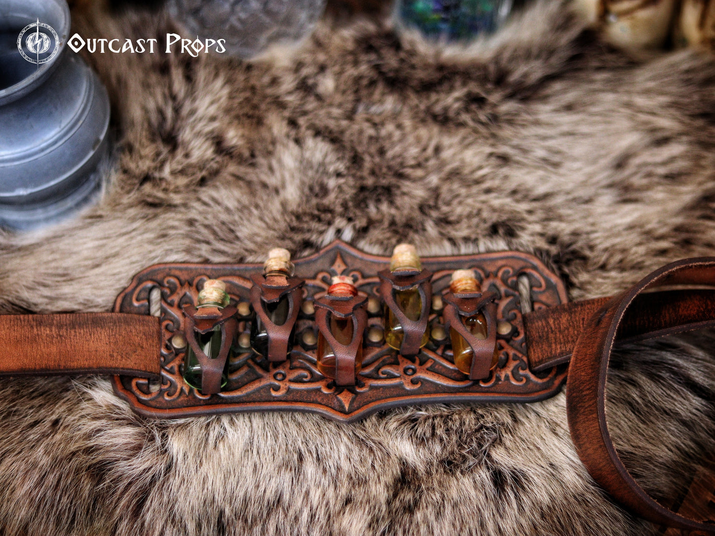 A handmade leather potion holder with ornate embossed patterns, designed to hold five small glass vials. The holder is displayed on a furry surface, and the vials have cork stoppers. Ornated Belt potion holder | 5  potion Belt carrier | LARP, cosplay, fantasy alchemist accessory, adventurers, steampunk, alchemist, healers