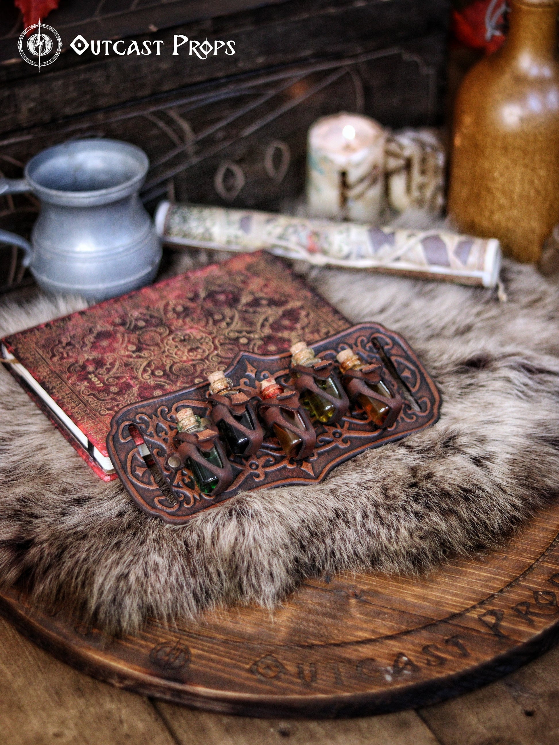 A handmade leather potion holder with ornate embossed patterns, designed to hold five small glass vials. The holder is displayed on a furry surface, and the vials have cork stoppers. Ornated Belt potion holder | 5  potion Belt carrier | LARP, cosplay, fantasy alchemist accessory, adventurers, steampunk, alchemist, healers