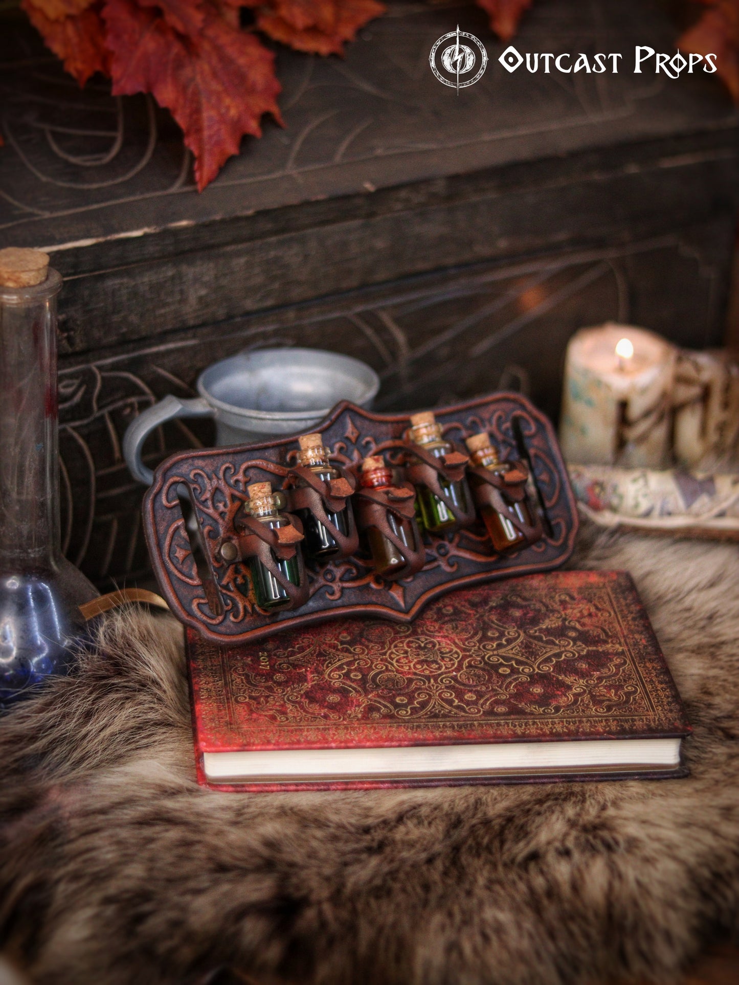 A handmade leather potion holder with ornate embossed patterns, designed to hold five small glass vials. The holder is displayed on a furry surface, and the vials have cork stoppers. Ornated Belt potion holder | 5  potion Belt carrier | LARP, cosplay, fantasy alchemist accessory, adventurers, steampunk, alchemist, healers