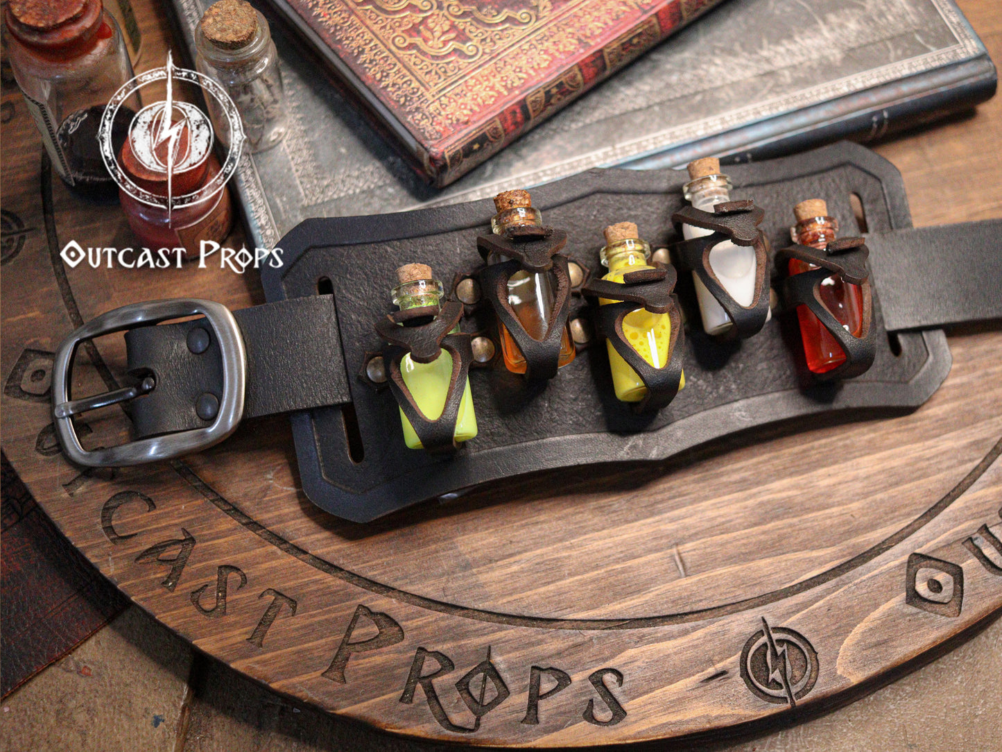 Belt with small bottles and 'Outcast Props' branding on a wooden surface. Belt Potion holder for 5 small bottles. Made of leather for adventurers, steampunk, alchemist, healers, cosplay or just to keep spices