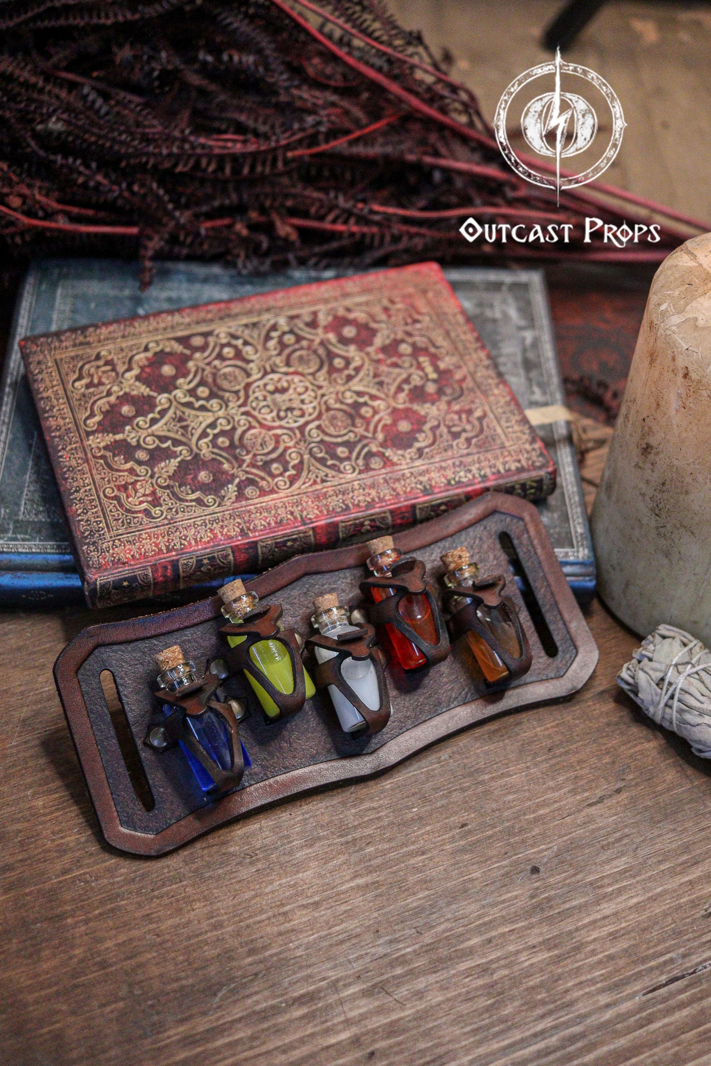 Set of small potions in a leather holder with an ornate book and decorative elements on a wooden surface. Belt Potion holder for 5 small bottles. Made of leather for adventurers, steampunk, alchemist, healers, cosplay or just to keep spices
