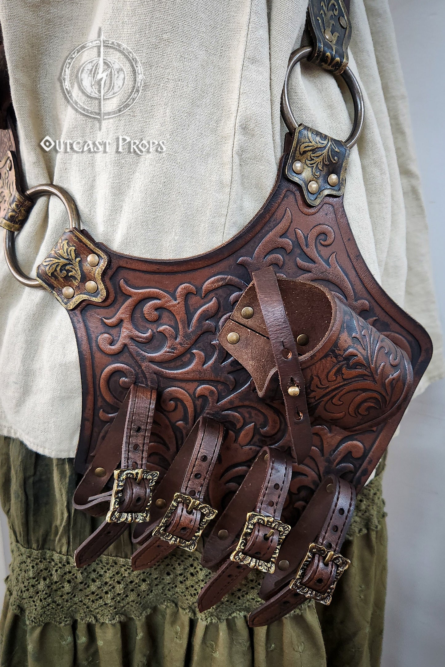 Brown leather quiver with intricate designs on a person wearing a white shirt and green pants. Pirate baldric for 4 flintlock pistols and a sword, inspired by Blackbeard, Anne Bonny, Captain Kidd and Pirates of the Caribbean. Ideal for LARP, Renfaire, renaissance fair, Pirate Weekend, cosplay, Halloween and Black Sails. Silver-engraved leather, handmade with vegetable-tanned leather. Premium pirate shoulder belt for Jack Sparrow costume, historical reenactment and fantasy events. High quality pirate accesso