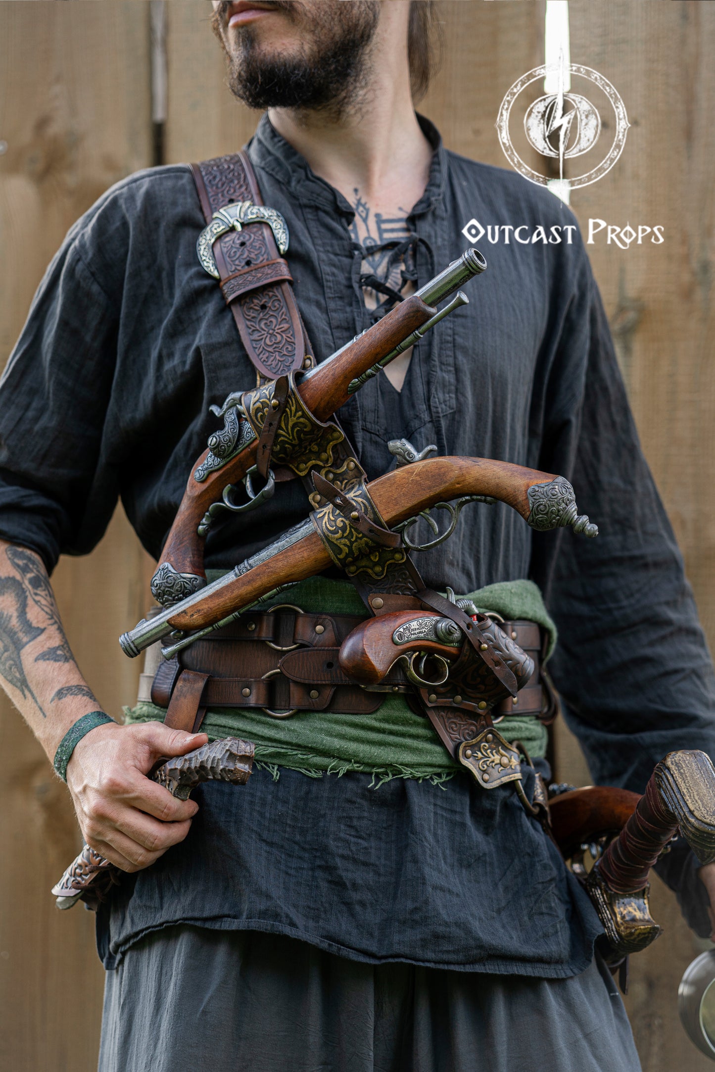 Close-up of a pirate baldric holding four flintlock pistols across the chest, crafted from engraved leather. Inspired by Pirates of the Caribbean, this premium belt is ideal for Jack Sparrow cosplay, LARP, renfaire and fantasy events. The leatherwork features silver details and historical styling. Perfect for pirate costumes based on Anne Bonny, Blackbeard or Captain Kidd. A high-quality fantasy accessory for reenactment and photoshoots.