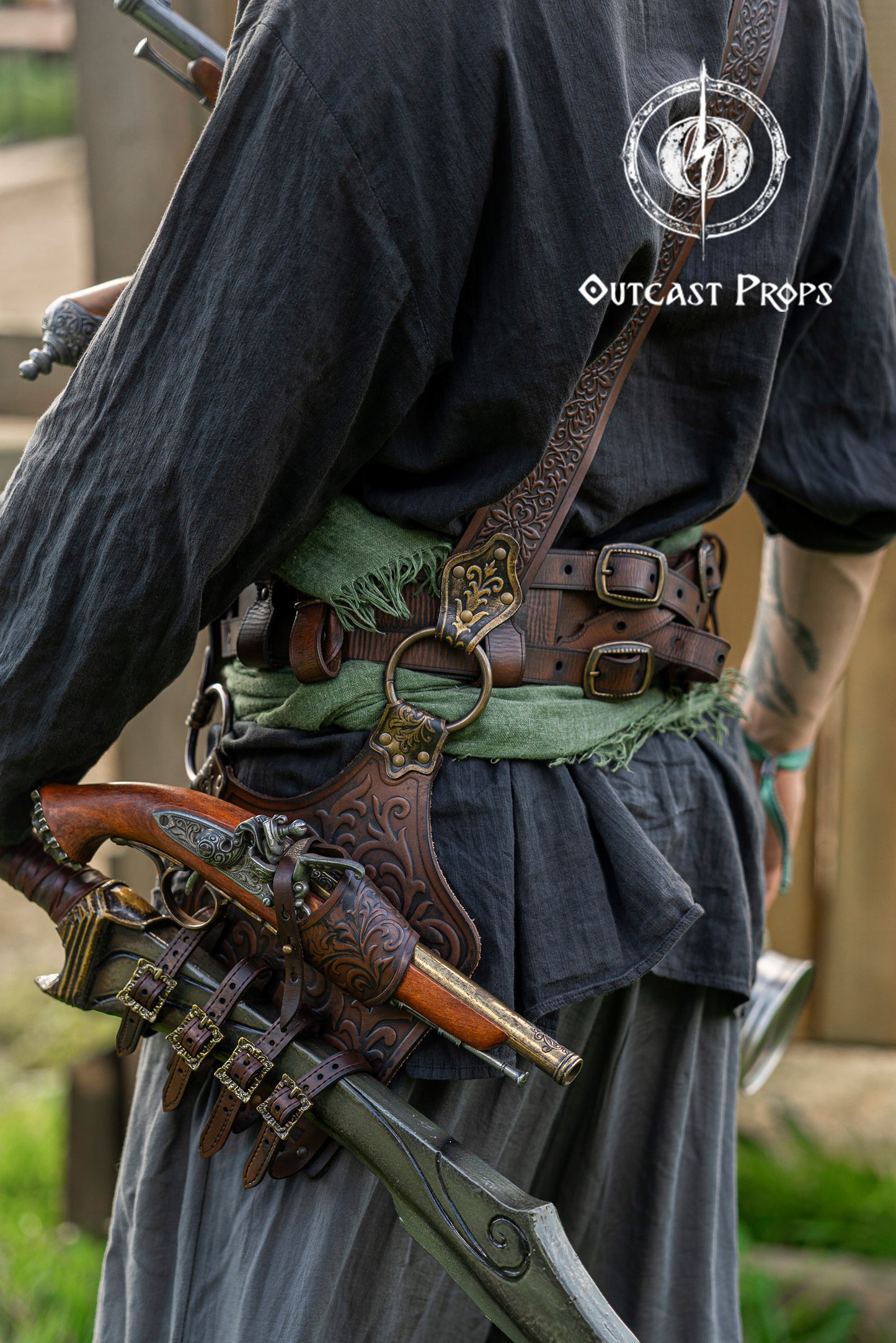 Back view of a pirate baldric showing intricate silver engravings, one flintlock pistol, and a sheathed cutlass. Inspired by historical pirates and fantasy characters, this shoulder belt is ideal for LARP, cosplay, and renaissance fairs. Crafted from premium vegetable-tanned leather with attention to detail. Perfect for Jack Sparrow, Black Sails, or Pirate Weekend looks. Great for costume design, photo sessions, and fantasy events.